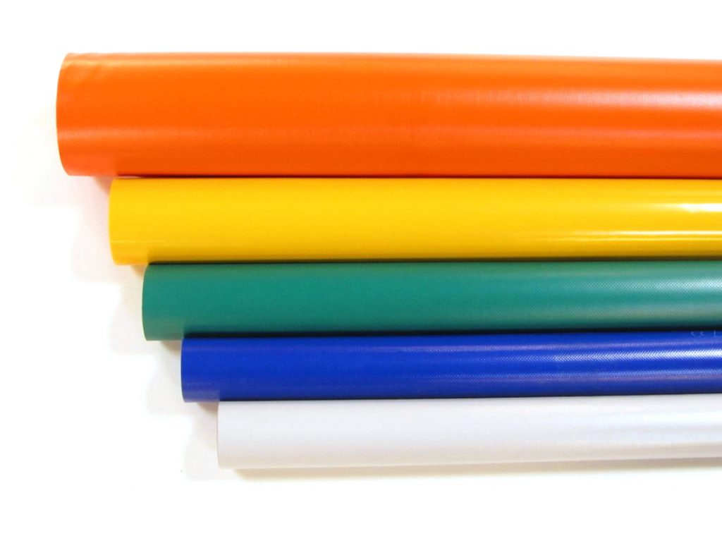 rollen met PVC zeildoek in de kleuren, oranje, geel, groen, blauw en lichtgrijs